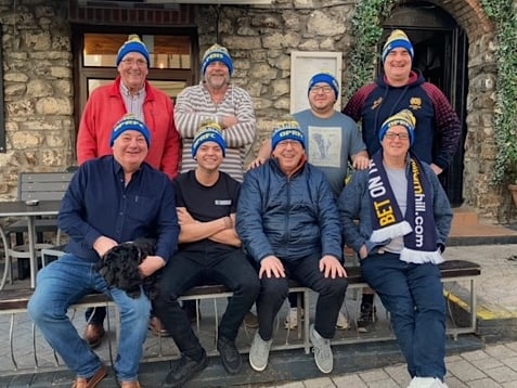 Saundersfoot group of friends outside the Royal Oak showing support for Ukraine in their choice of Old Penarthians bobble hats that match the Ukrainian flag colours.