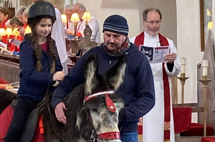 Zoey riding Andy the donkey in St. Mary’s Church, Tenby on Palm Sunday
