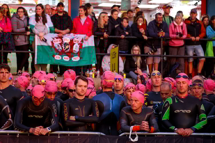 TENBY, WALES - SEPTEMBER 11: Athletes and spectators observe a minutes silence for the Queen ahead of IRONMAN Wales on September 11, 2022 in Tenby, United Kingdom. (Photo by Nigel Roddis/Getty Images for IRONMAN)