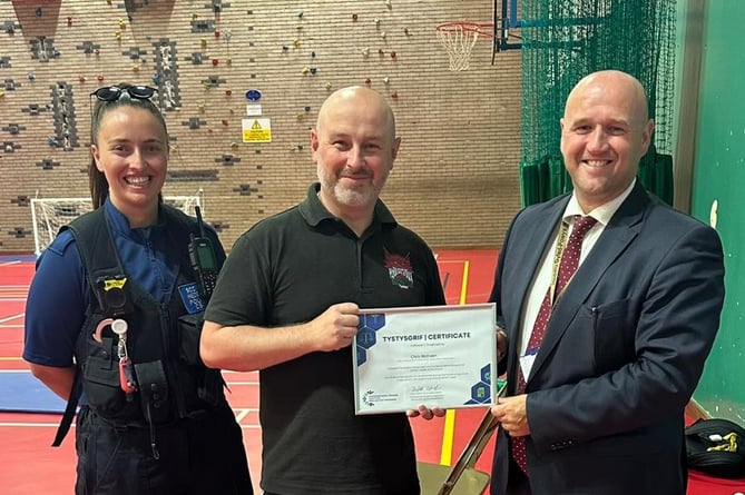 PCSO Laura Edwards, and PCC Dafydd Llywelyn presenting certificate to Chris McEwen of BOXWISE