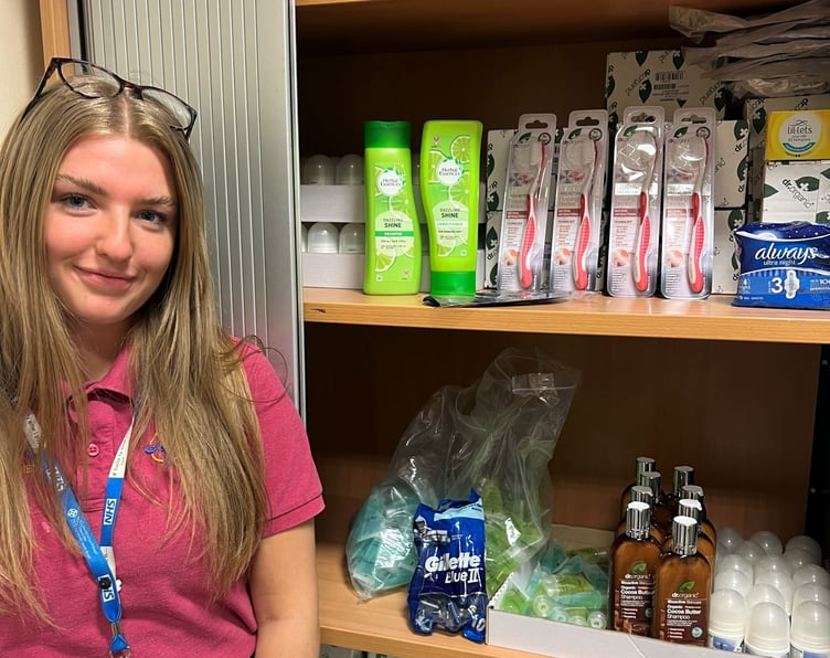 Honey Owens, Patient Experience Apprentice with toiletries purchased with donations to Hywel Dda Health Charities.