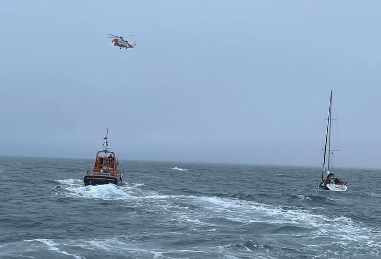 Angle RNLI and Coast Guard Rescue Helicopter with damaged yacht