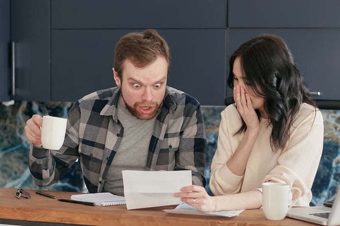 https://www.pexels.com/photo/a-couple-sitting-near-the-wooden-table-while-looking-at-the-document-in-shocked-emotion-6963032/