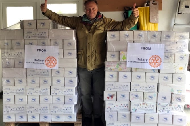 Rotarian John giving thumbs up for another successful year for the Shoebox appeal, with two full pallets of boxes ready for collection.