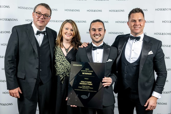 Members of the Folly Farm Holiday Park team, Zoe Wright (Second Left), Alex Torok (Left), and Dafydd Bevan (Second Right), receive their award from Luke Hansford, Senior Vice President - Supply at Hoseasons (Right).