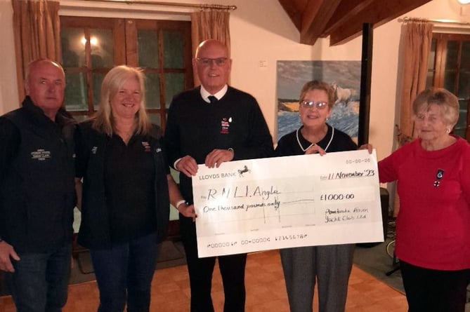 Members of the Angle branch of the RNLI being presented with the donation at Pembroke Haven Yacht Club.