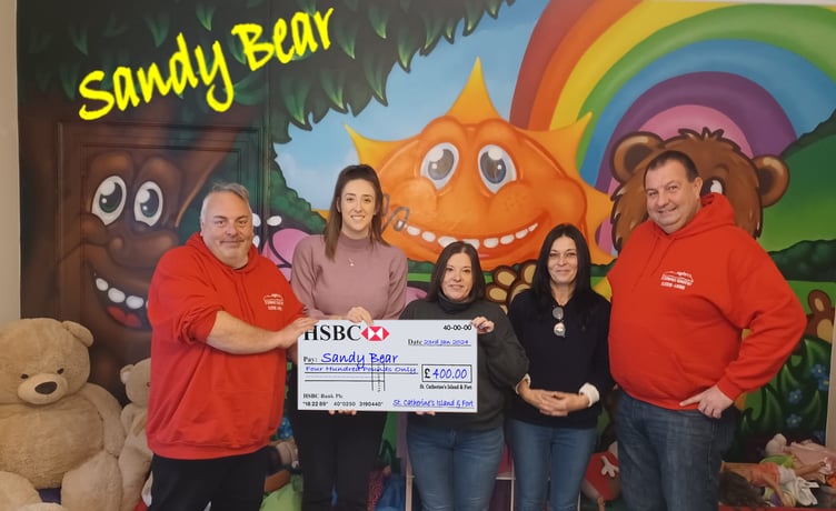 Sandy Bear’s Hannah Beer and Michelle Joseph being presented a cheque for £400 by volunteers at St. Catherine’s Island and Fort.