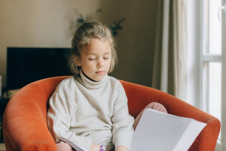 Blind child reading braille book