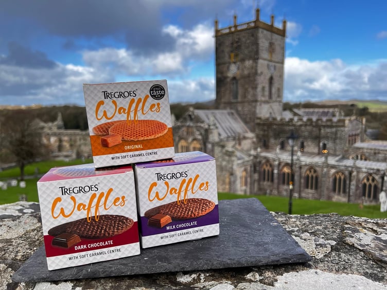 Packs of Tregroes Waffles stacked against the backdrop of the iconic cathedral at St Davids, Pembrokeshire.