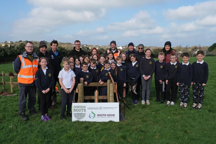 Johnston pupils plant trees in the school grounds with the support of Tom Bean and Will Whittington of Pembrokeshire Coast National Park Authority, along with Hamad Al Samra and the team from South Hook LNG Terminal.