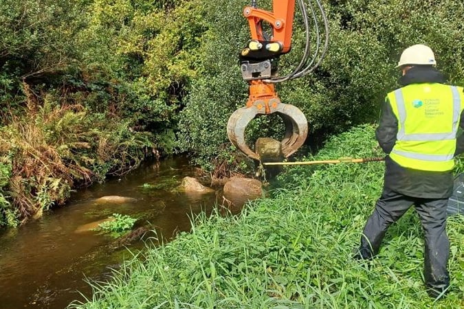 Long reach machinery placing boulders into a stretch of the Western Cleddau River, near Letterston village