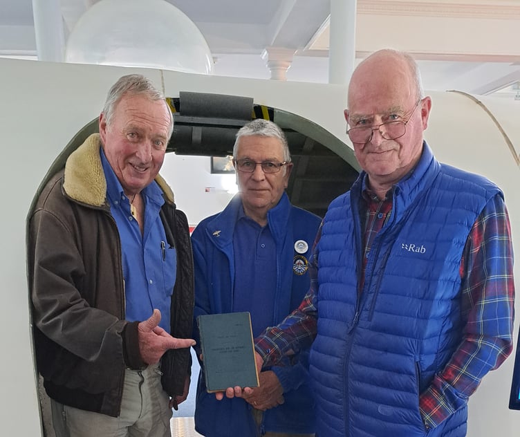 Chris (left) and Ross Burrows show their father’s logbook to Heritage Centre Trustee Rik Saldanha.