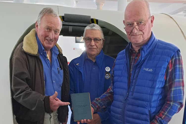Chris (left) and Ross Burrows show their father’s logbook to Heritage Centre Trustee Rik Saldanha.