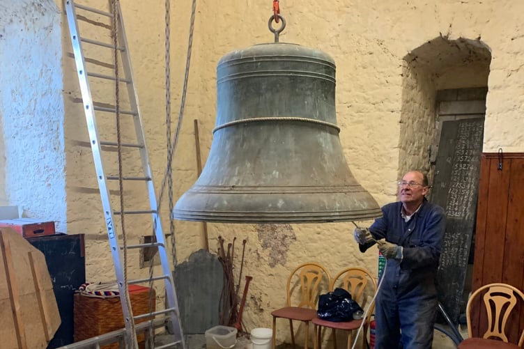 Bell hanger Peter Hayward guides the tenor bell down the tower.