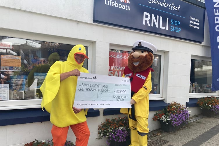 Quackers, from Saundersfoot Rotary, presenting RNLI’s Stormy Stan a cheque for the £1,000 raised at Saturday’s Duck Race.