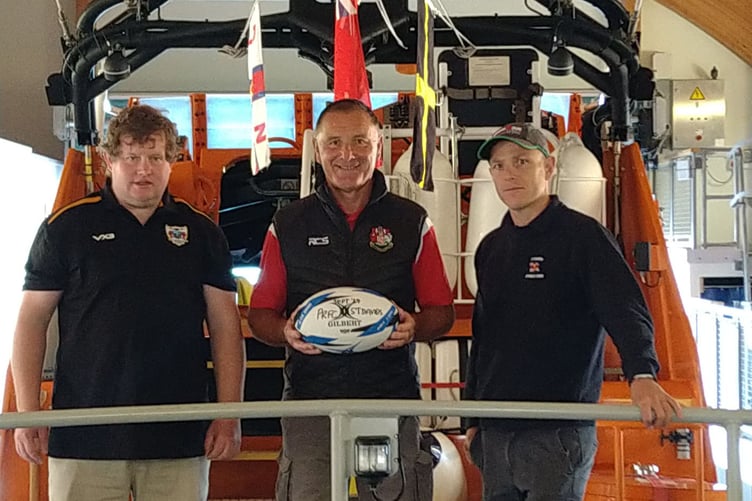 Darrell Willington hands over the match ball to Rhys Price Saints RFC and Will Chant of RNLI St Davids