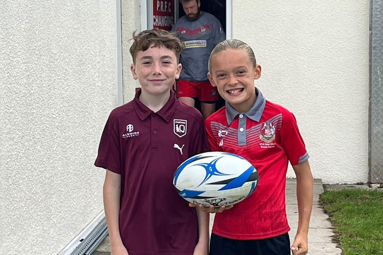 Two junior players about to run match ball to the team captains for the kick off
