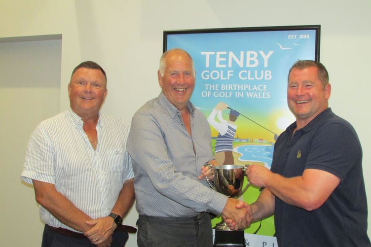 Tenby's Neil Thomas and Mick Seal receive the Loz Phillips Cup from Pannard's Match Captain, Peter Greenslade