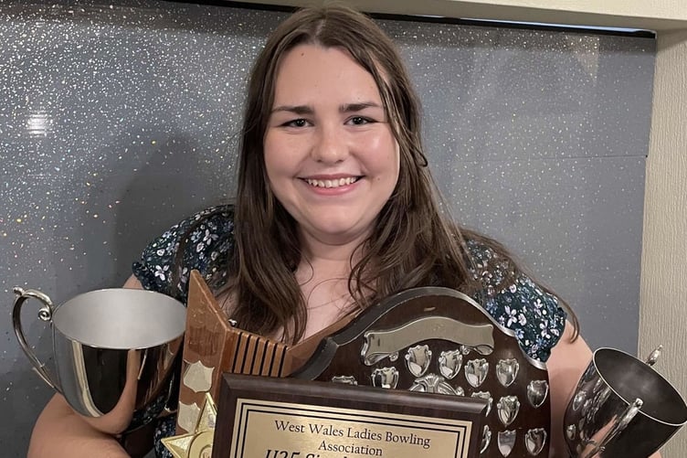 A smiling Katie Dickinson with her magnificent haul of trophies