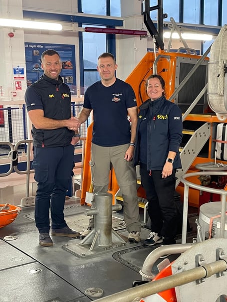 Rob Garland being congratulated after his passing out as Deputy Coxswain by Marc Gibbons, RNLI trainer and assessor; and Tenby Coxswain, Lisa Viggers.