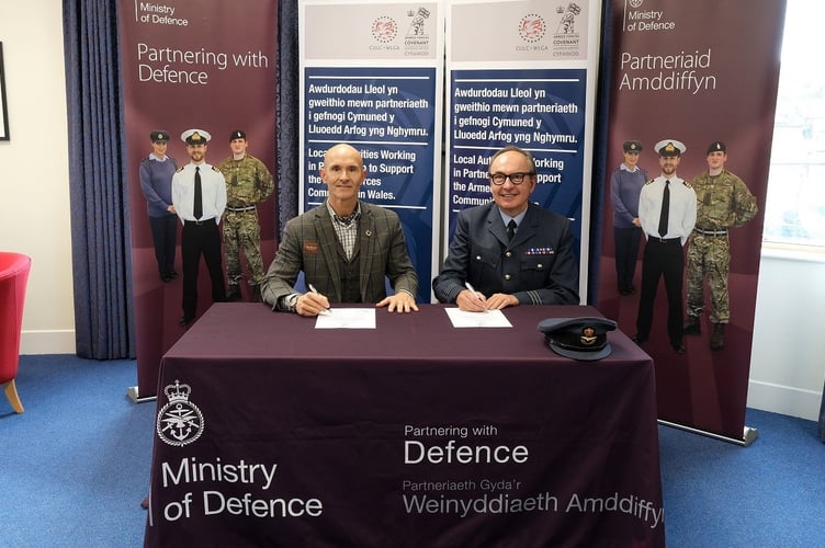 Marten Lewis, Director of Sustainability, signing the covenant with Craig Middle of the MoD.