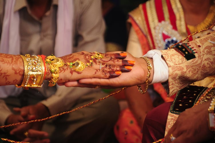 The hand of the bride held by a groom during a Indian traditional ritual