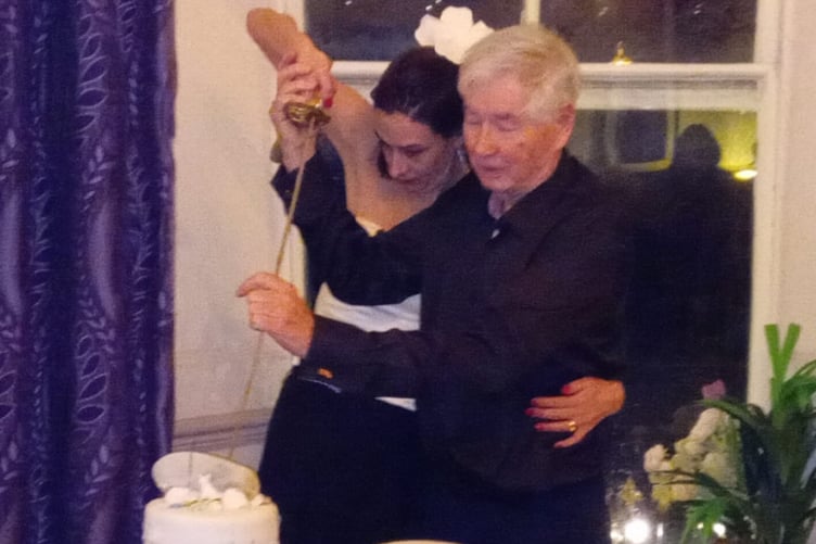 Local author Cyril James Morris, Lt Cdr, Rtd, and his wife Louise using Cyril’s ceremonial sword to cut their wedding cake during their reception at The Belgrave Hotel, Tenby.