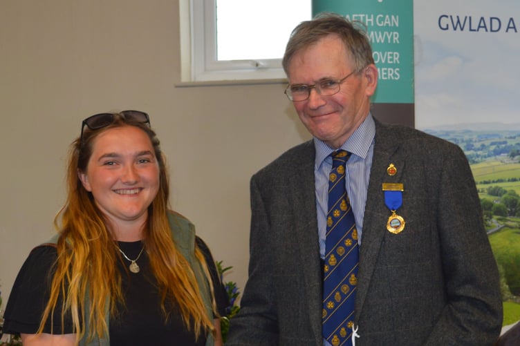 2023 Pembrokeshire County Show bursary winner Lottie Wilson receiving her £1,000 prize from Robert James