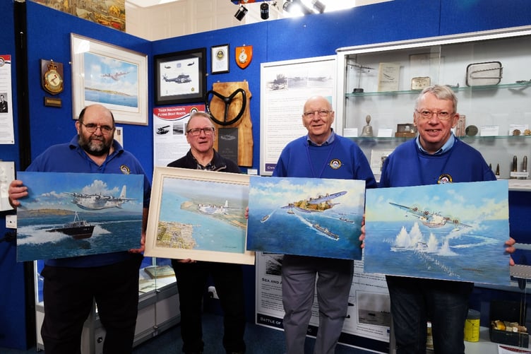 Artist John Wynne Hopkins and three of the Pembroke Dock Heritage Centre Volunteer Team display the original Sunderland paintings. Left to right: Martin Vickery, John Wynne Hopkins, Steve Lyons and Mike Reeve. Photo: Martin Cavaney Photography