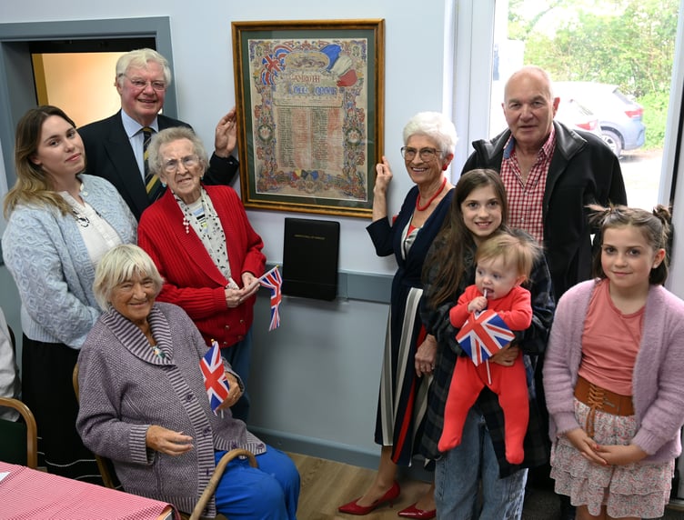 With the rededicated Roll of Honour at Amroth Parish Hall are Lieut Col Charles Carter, India Griffith, Jane Hall, Pam Gibson (seated), Rosemary Tippett Maudsley, William Thwaites, Beatrix Wilson holding her baby brother Rex, and Florence Wilson.