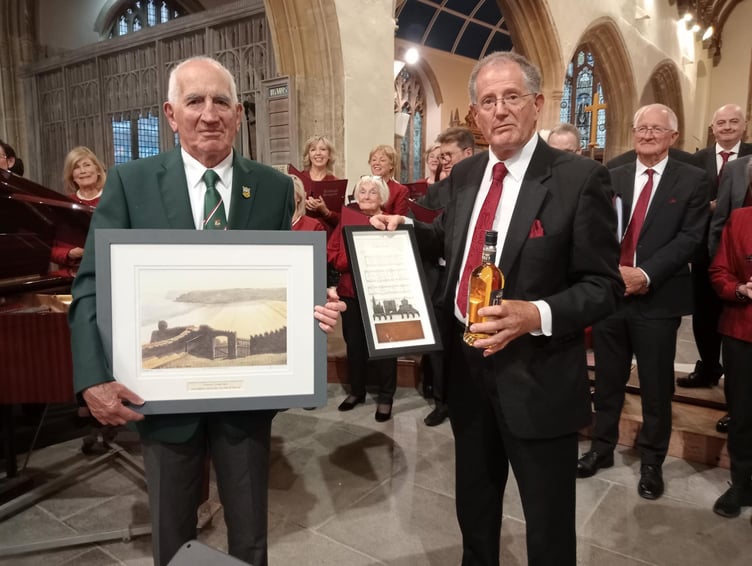 Choir chairmen Huw Morgan (left) and Vincent Moore exchange gifts.
