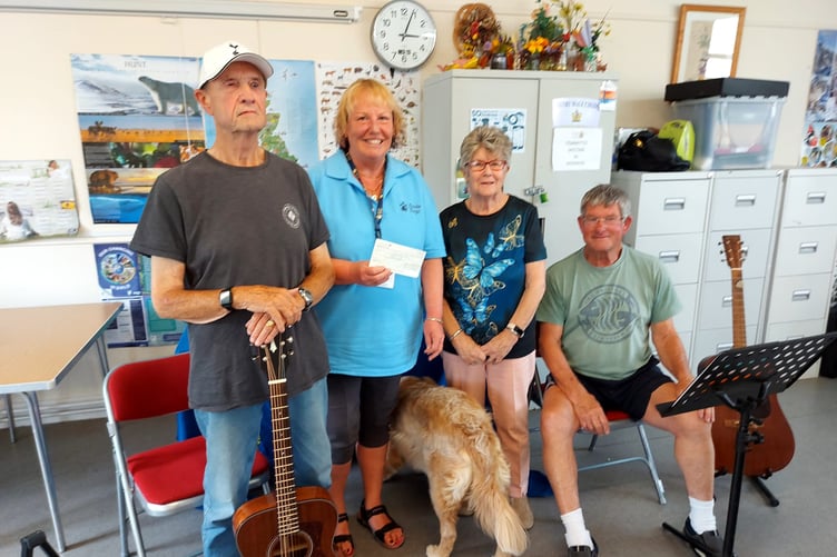 Seen with musicians John and Chas, Sue Canham receives the cheque for Guide Dogs Cymru from Tenby Friendship Club chair Anne Elms