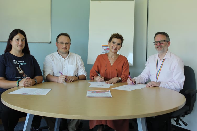 The HIV pledge being signed by Chief Executive Dr Phil Kloer, Executive Director of Public Health Dr Ardiana Gjini, and Sexual Health Consultant Dr Adam Tyler.