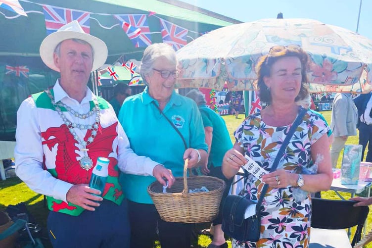 Neyland Mayor Peter Hay and Prif Weinidog Eluned Morgan at the Ladies Choir’s stall, drawing raffle tickets at the town’s carnival