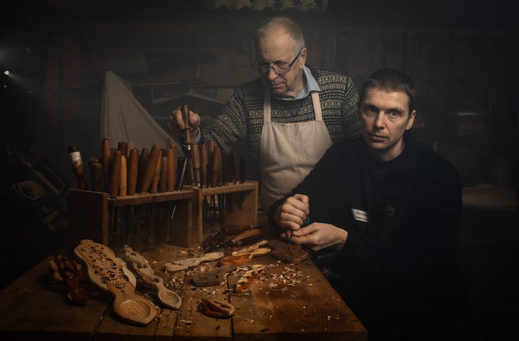 In the image: Kerry Thomas (left) and David Thomas (right). The Lovespoon Workshop, Kilgetty, Pembrokeshire, draws visitors from around the UK and rest of the world where they are keen to watch and learn about the traditional Welsh art form of Welsh lovespoon carving. Lovespoon carving is a 17th century Welsh tradition, no two lovespoon is the same, made out of its own unique piece of wood, with a Welsh knot and unique combination of motifs, illustrating a personal story or milestone, such as an engagement, wedding, anniversary etc. The Lovespoon workshop opened in 1975 by Kerry Thomas, 74, and his wife Jill, however, Kerry has Wood carving since 1969 after he made his first lovespoon to propose to his wife with.
Now Kerry carves lovespoons with his son David, 41, with their lovespoonâs in high demand, being sold internationally. Even though this time of year around valentines day is busy for the father and son team, they continue to make lovespoons all year round.
Kerry explains the company is an eco business, âall the wood is either from recycled from windows and doors, and the oak that we get is again recycled or from a sustainable source. Itâs so important today to make things sustainable.â However, âsadly the vast majority, that could be as much as 90% of love spoons that you see in Wales are made in either Africa, India or China.â 
Kerry goes on to say âas far as handmade love spoons are concerned very few people in Wales are making them. Unfortunately, the Welsh Assembly, weâve informed them that the lovespoons are being made abroad, they are coming into our country and being sold as âWelshâ lovespoon. They are being marketed as âWelshâ lovespoons, and theyâre not.â 
In itself, even on this small business scale, by importing fake âWelshâ branded traditional goods such as this goes against the Welsh Governments very own âGreen Growth Pledgeâ which is designed to âWales transition to a low carbon future.â Other contra