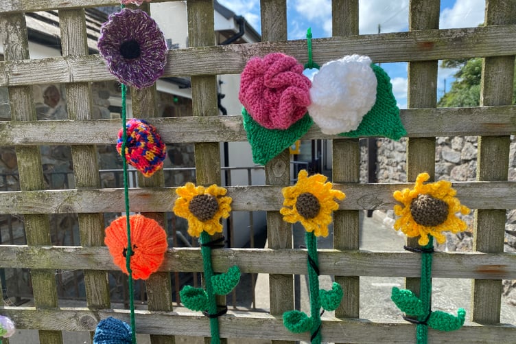 Yarn bombers’ handcrafted flowers near the entrance to Penally Village Hall