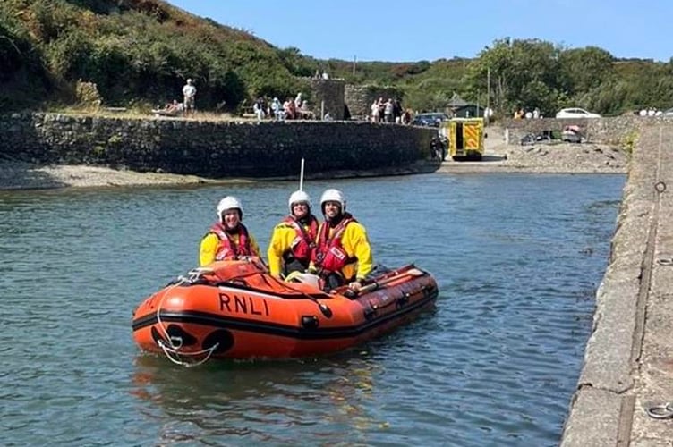 Inshore lifeboat and crew leaving casualty in the care of ambulance crew at Porthclais harbour 