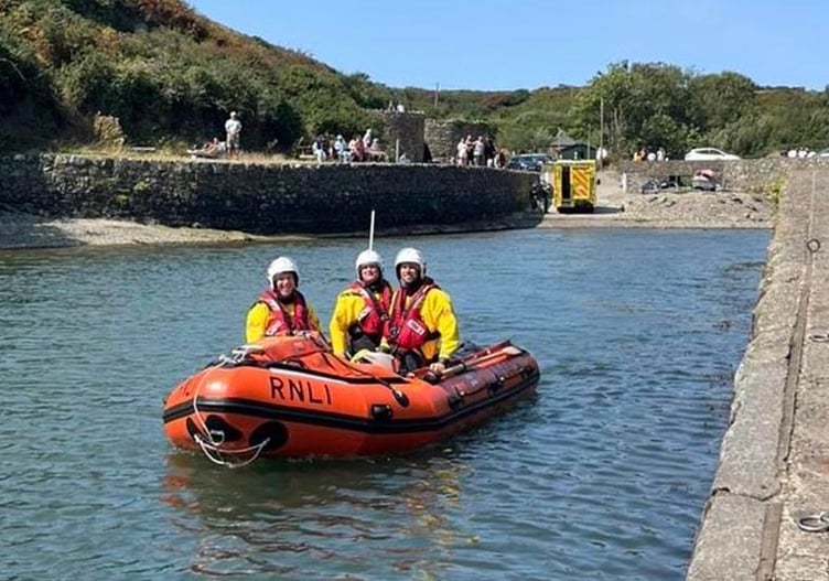 Inshore lifeboat and crew leaving casualty in the care of ambulance crew at Porthclais harbour