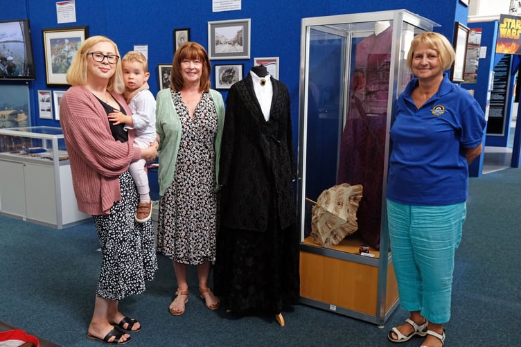 New generations of Anna Jane Abbott Rees’ family with her dresses - great-granddaughter Jane Phillips, Natalie her daughter-in-law and grandson Rowan with Dawn Pickering, Volunteer of the Heritage Centre Collections Team.