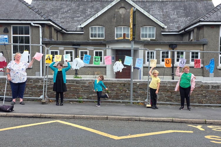 Claire Warren (left) her daughter Charlotte (far right) and other pupils outside Carway Community Primary School, Carmarthenshire