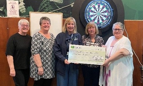 Pictured above: Members of the Carmarthen and District Ladies Winter Darts League and fundraising officer Claire Rumble
