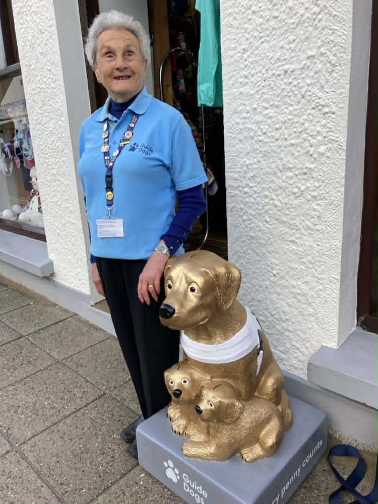Eva Rich with the gold-coloured collecting box for Guide Dogs Pembrokeshire
