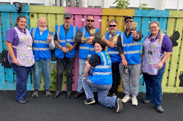 Members of the 3 Amigos and Dollies Motorcycle Group joined by Cilgerran ward staff during their face lift of the outdoor play area
