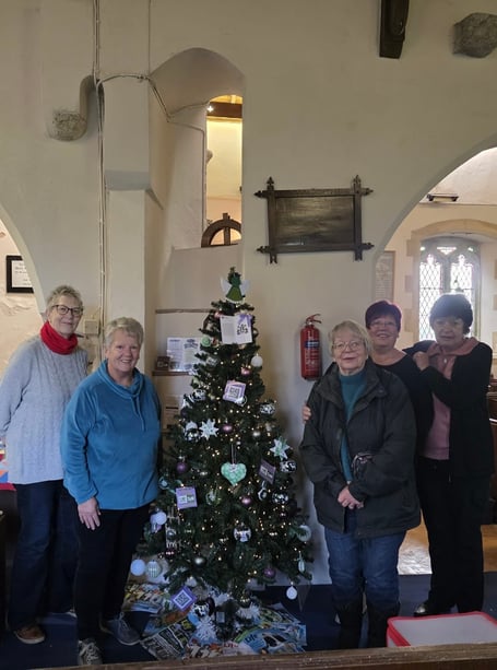 Members of Kilgetty WI decorating a Christmas tree in Begelly Church