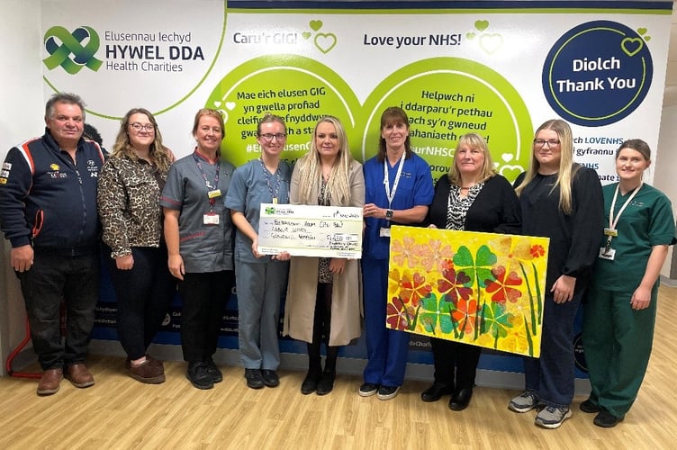 Kimberley Davies (centre) presents a cheque to the Midwifery Team  