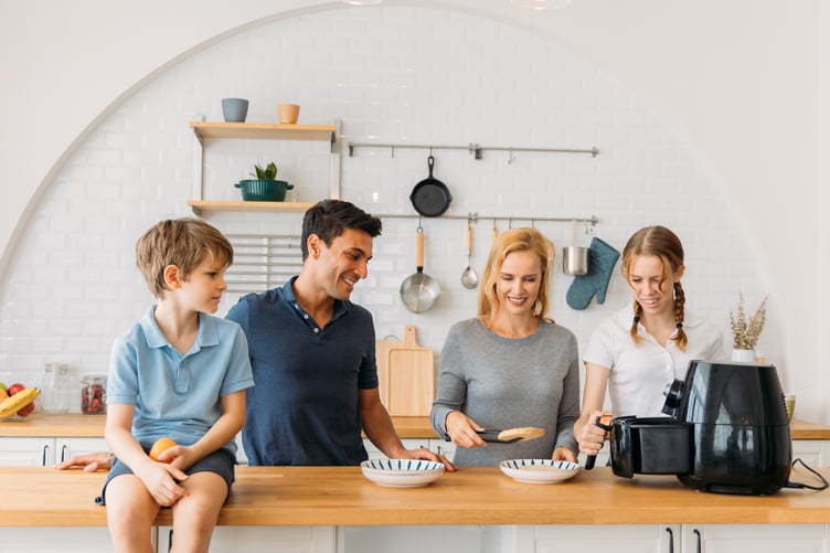 family cooking with air fryer in kitchen