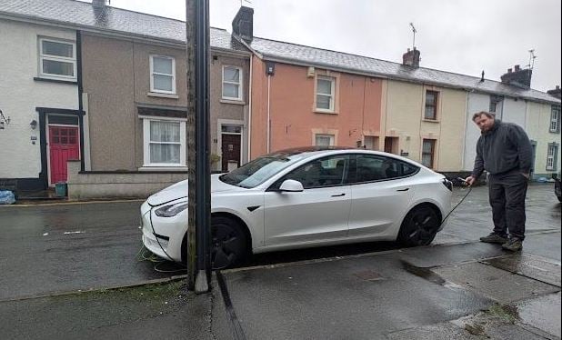 William Britton charging his Tesla at home in Llandovery with the cable duct in line with his front tyre (pic courtesy of William Britton and free for use for wire partners) 
