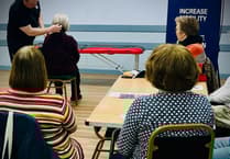 Chiropractor demonstrates treatment and exercises at Summerhill WI meeting