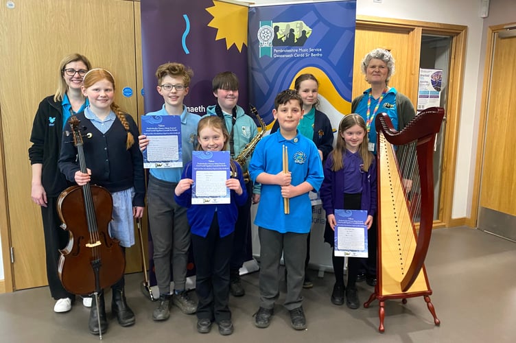 Pictured are overall winner Carys Meiring of Ysgol Hafan y Môr, and open winners L-R: Miranda Morgan (music coordinator), Mari Broomfield (open strings), Finn Hickman & Evelyn James (open ensemble), Osian Kite (open woodwind), Aled Hooper (open percussion),Carys Meiring (open brass), Cadi Marshall-Jones (open piano & harp) and Philippa Roberts (Head of Pembrokeshire Music Service). 