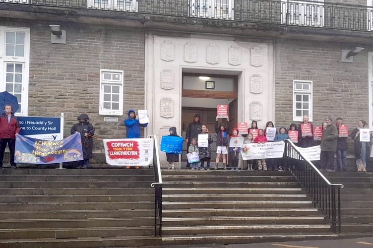 Pupils and parents on the steps of County Hall, Carmarthen, who don't want Ysgol Meidrim or Ysgol Y Fro to close (pic submitted by Cymdeithas yr Iaith and free